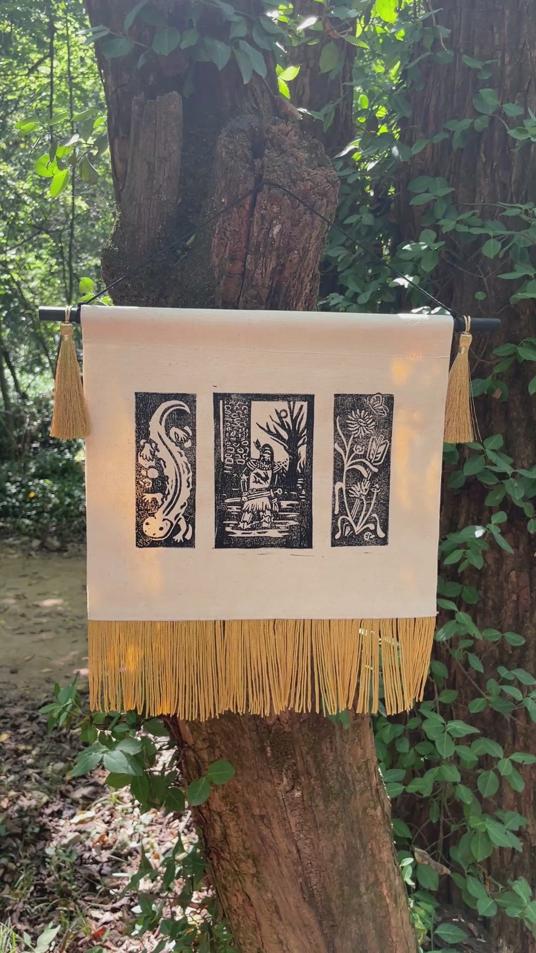 Video of the Sir Thomas Banner in a forest setting, the gold fringe at the bottom of the canvas banner billowing in the breeze.